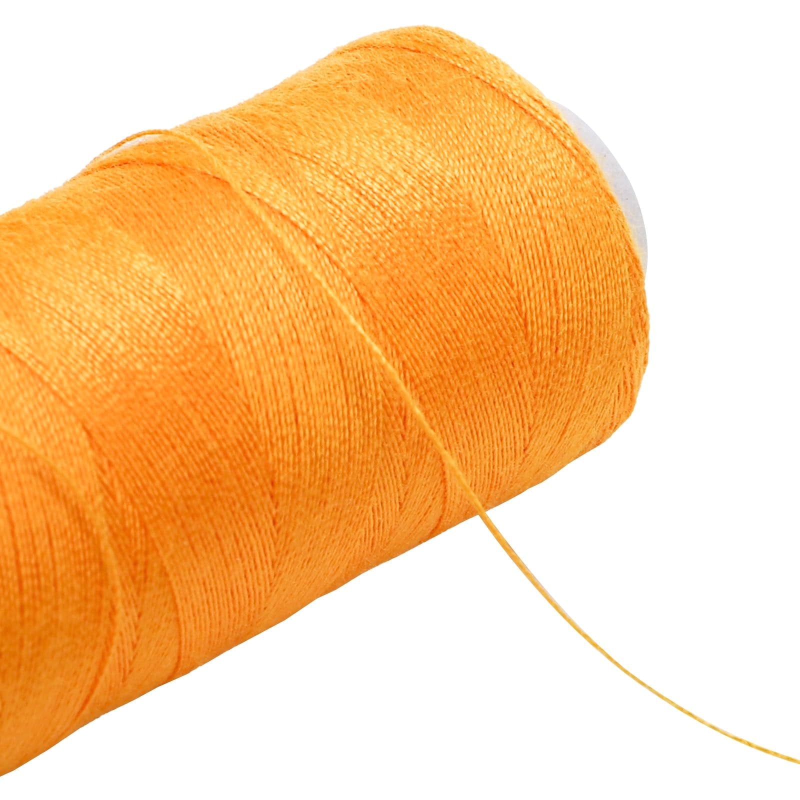 Close-up of an orange spool of polyester sewing thread with a loose end trailing off.