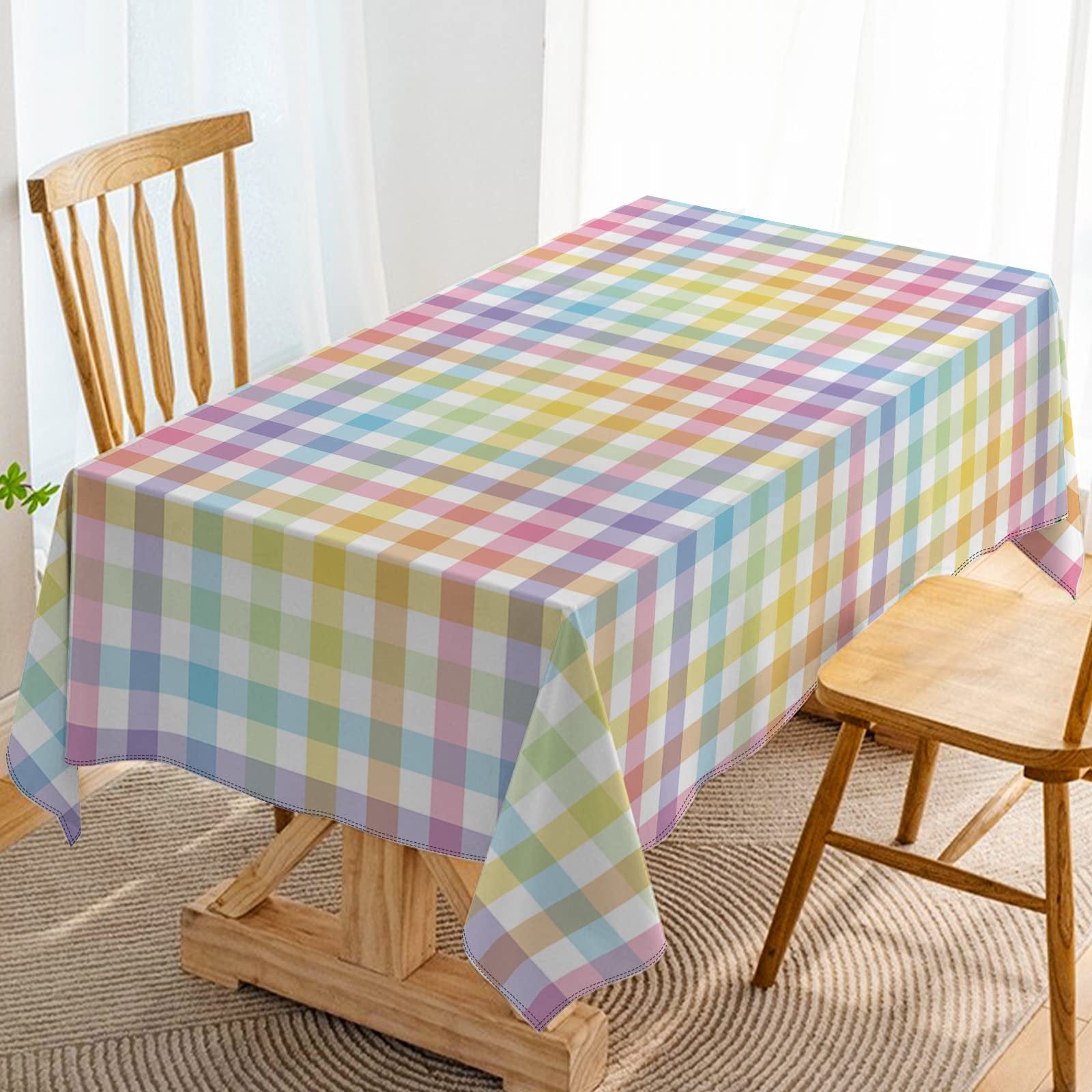 Pastel buffalo check plaid tablecloth draped over a wooden table with chairs