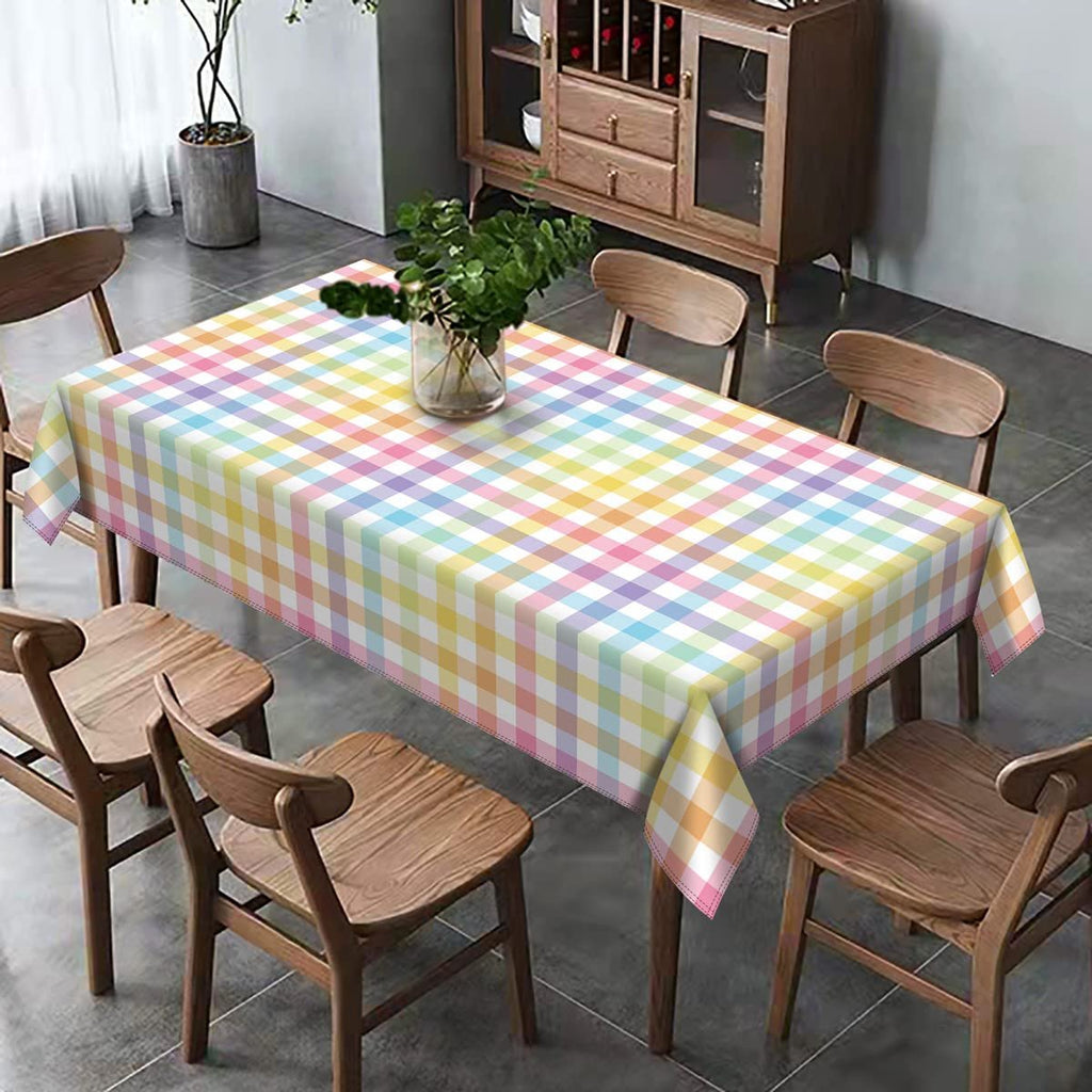 Rectangular tablecloth with pastel buffalo check plaid pattern draped over a dining table with chairs.