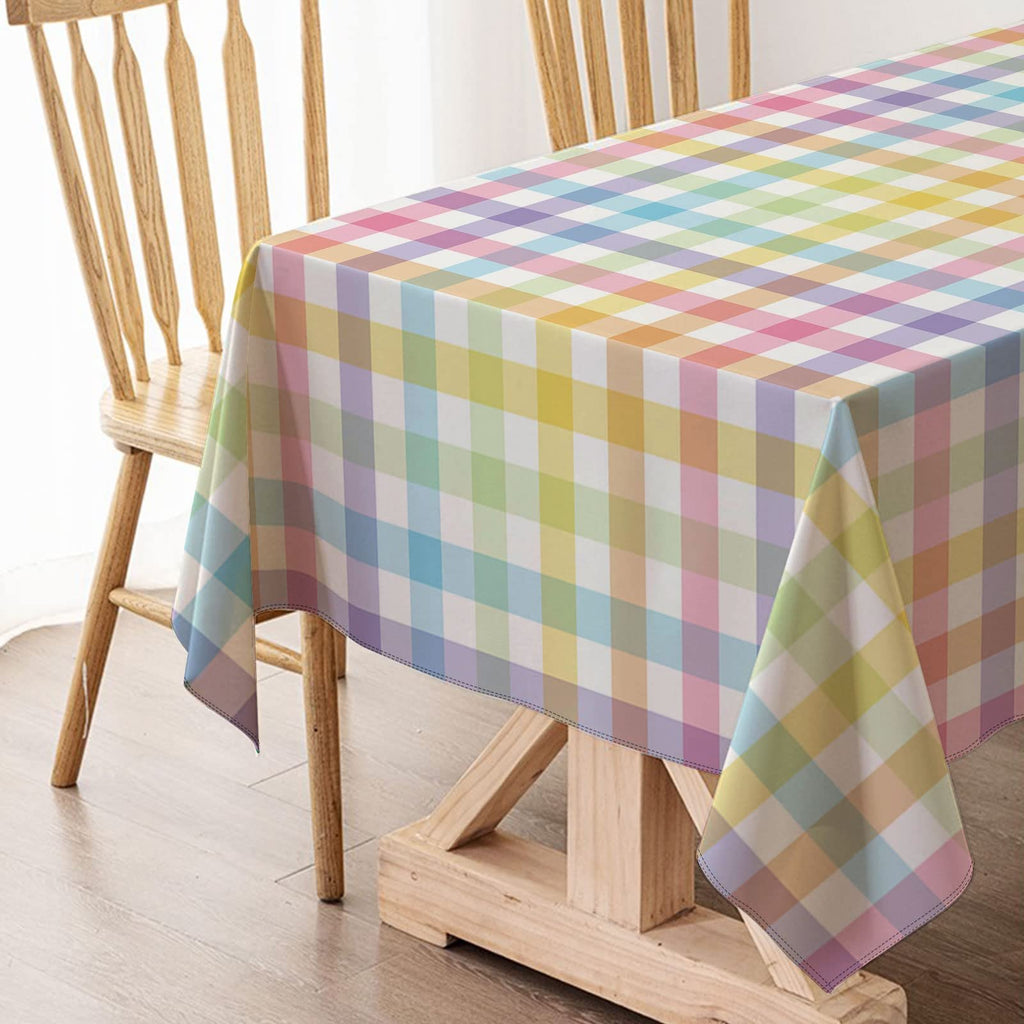 Pastel buffalo check plaid tablecloth draped over a wooden table with chairs