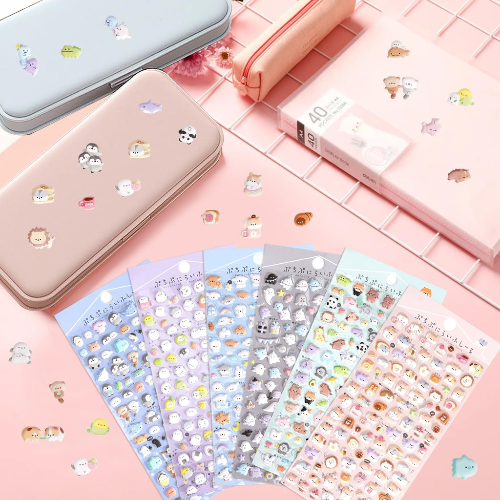 Collection of puffy 3D cartoon animal stickers on sheets and scattered around pencil cases and a notebook.