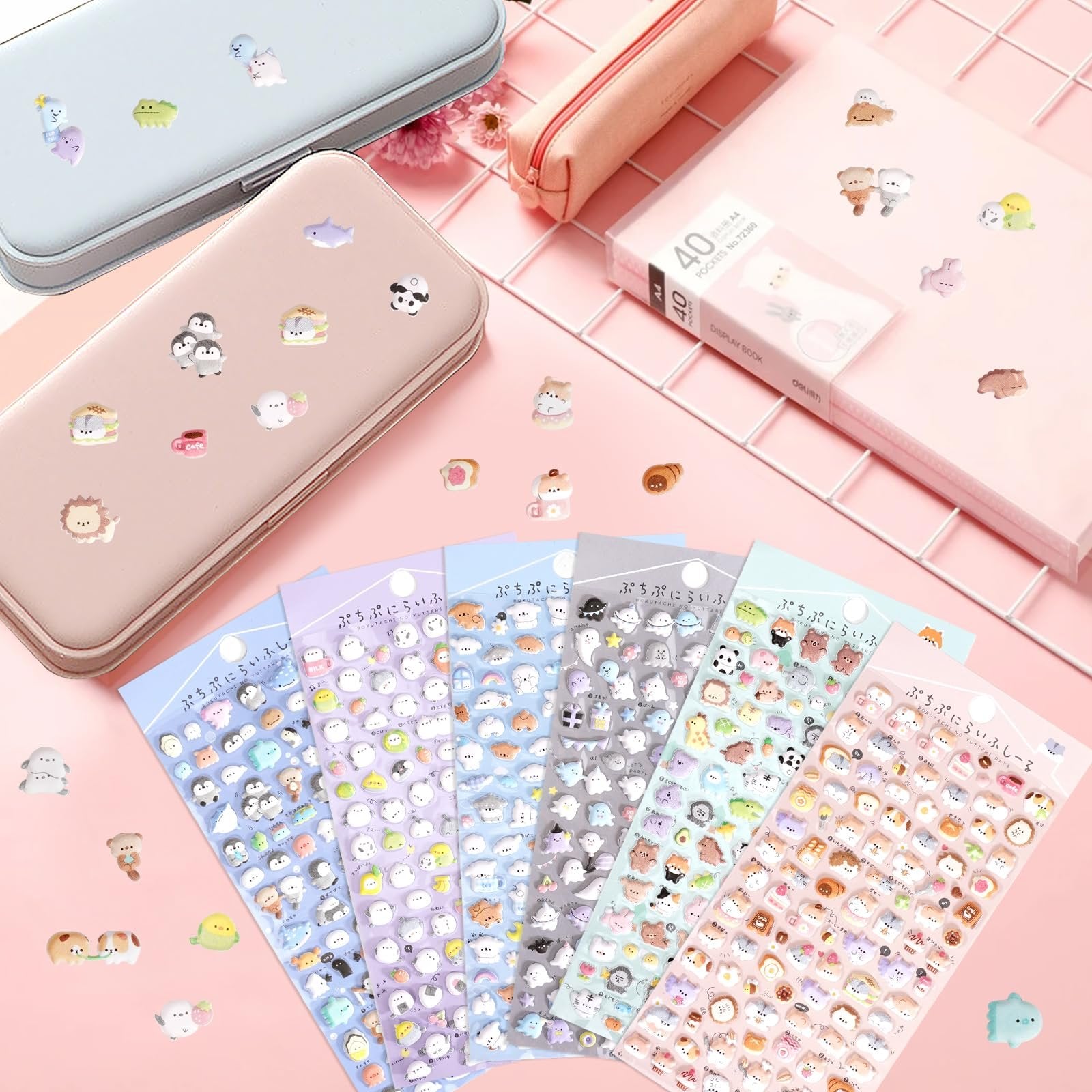 Collection of puffy 3D cartoon animal stickers on sheets and scattered around pencil cases and a notebook.