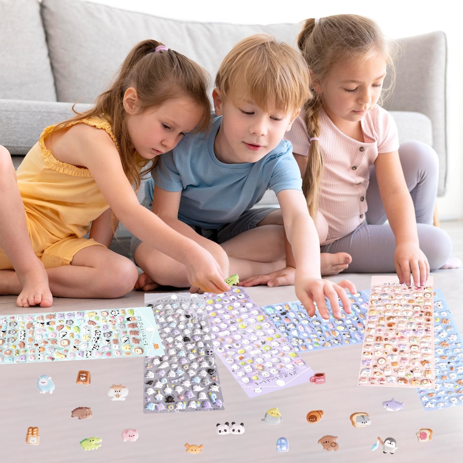 Three children sitting on the floor, looking down at sheets of puffy 3D stickers featuring cartoon animals and objects.