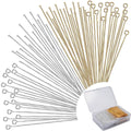 Assortment of gold and silver jewelry pins, including flat head and eye pins, displayed fanned out with a clear storage box in the corner.