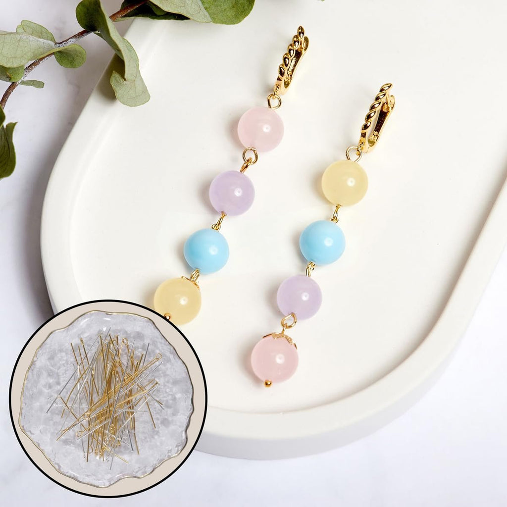Two beaded dangle earrings and a close-up inset of gold and silver jewelry pins on a white tray.