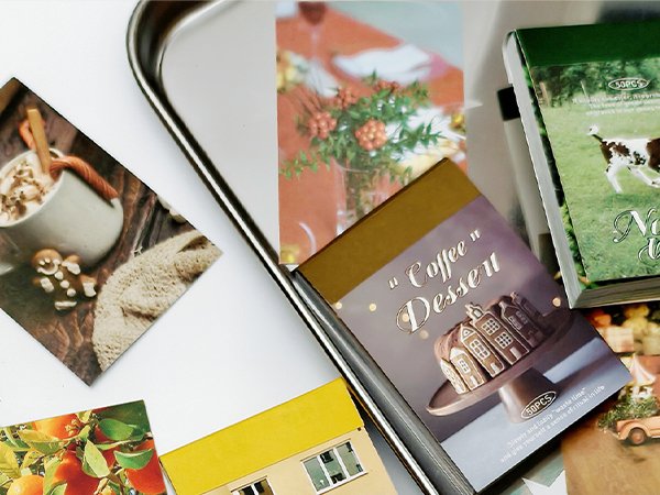 Collection of decorative stickers and postcards featuring coffee, desserts, fruit, and a cow.