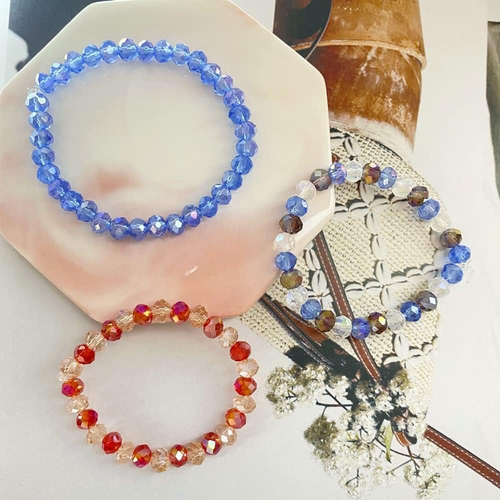 Three faceted crystal bead bracelets in blue, red/orange, and multi-color, arranged on a decorative surface.