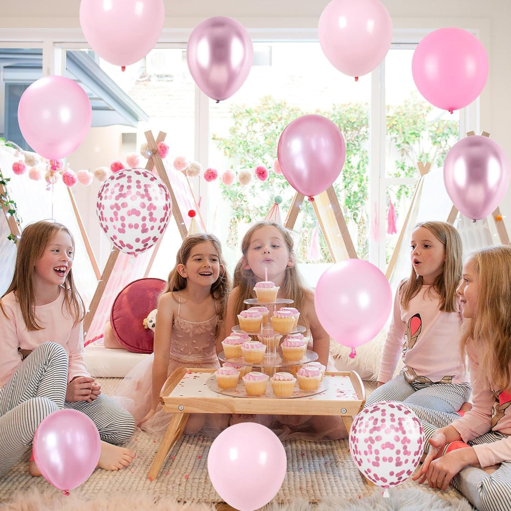 Children celebrating a birthday with pink and metallic balloons and cupcakes