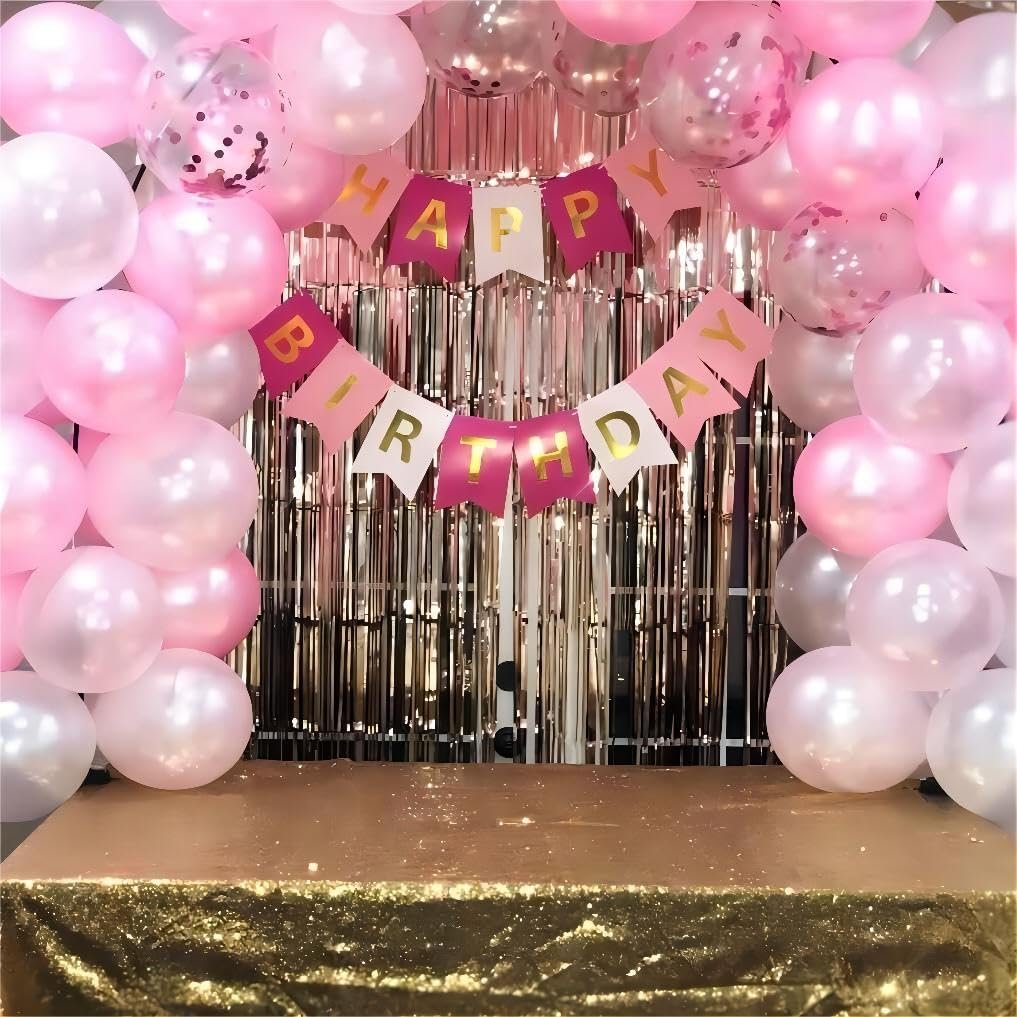 Birthday party backdrop with pink and white balloons, a metallic fringe curtain, and a 'Happy Birthday' banner.