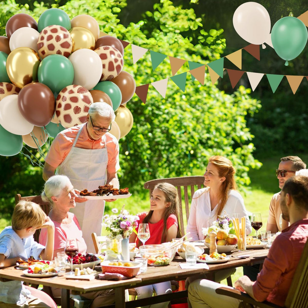 Family enjoying an outdoor barbecue with safari-themed balloons and bunting overhead
