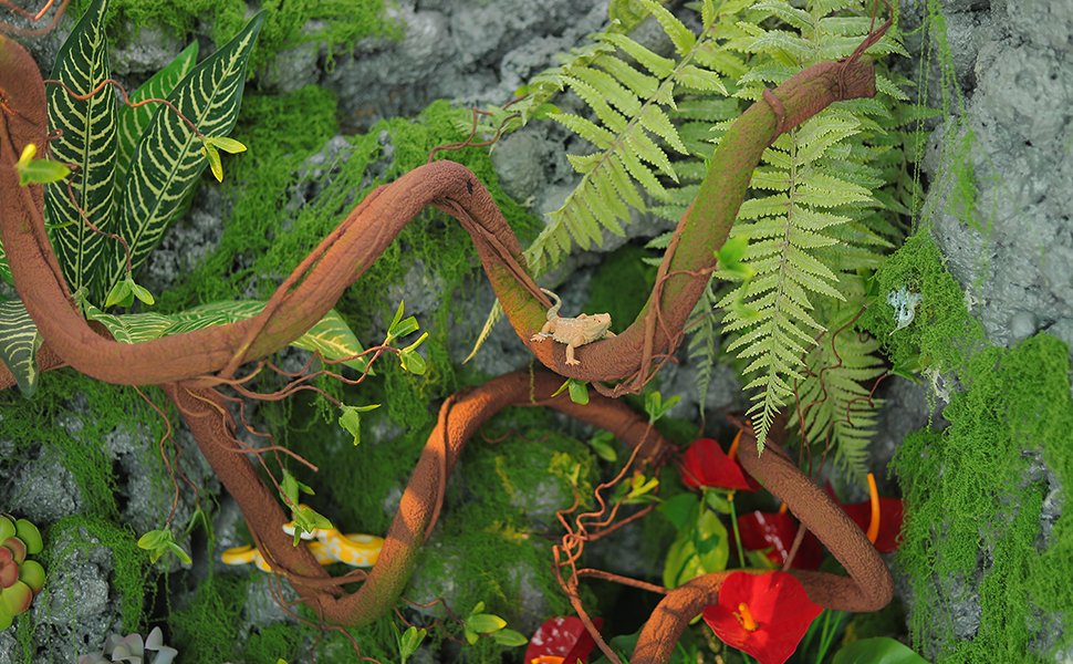 Bendable artificial tree vine garland with green shoots, faux wood cane, red flowers, and toy reptiles.