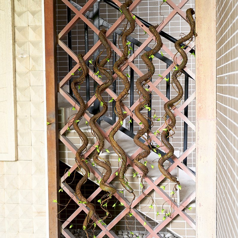 Artificial tree vine garland with green shoots draped on a lattice structure