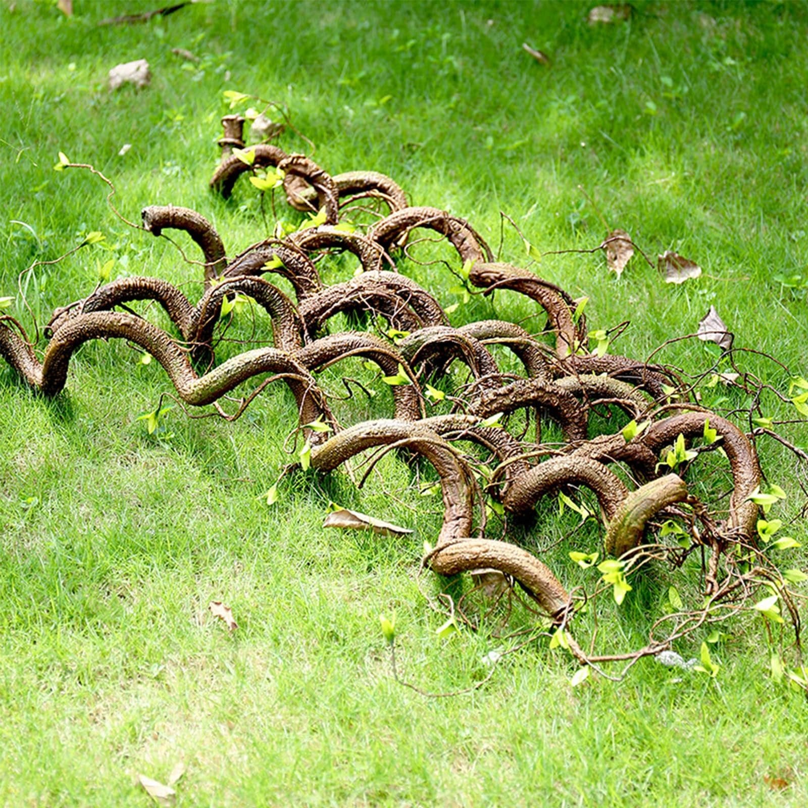 Bendable artificial tree vine garland with green shoots laid on green grass