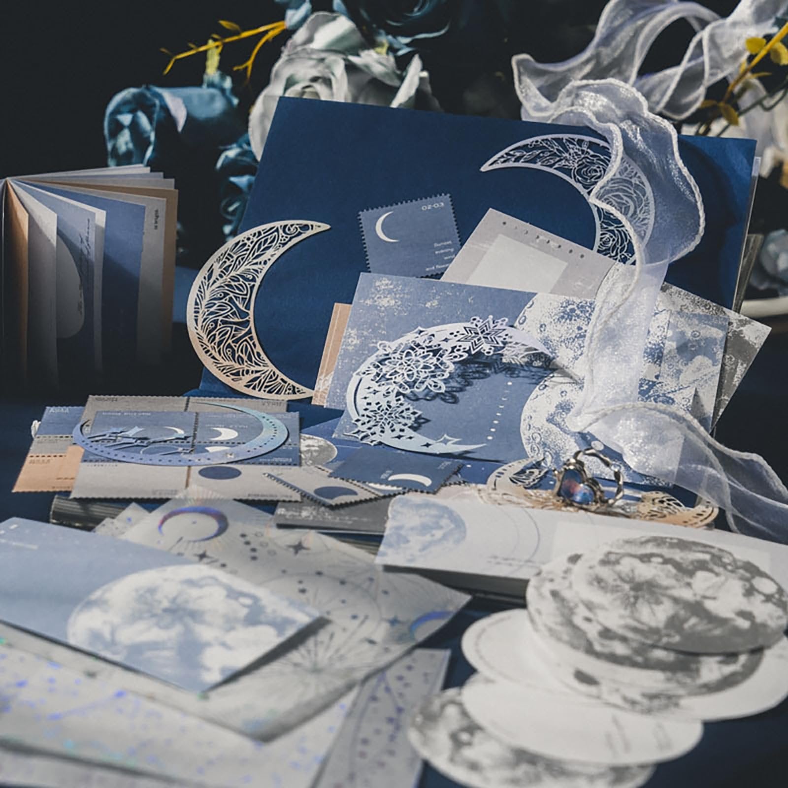 Scrapbook embellishment pack with moon and star designs, including paper sheets, stickers, and decorative cutouts.