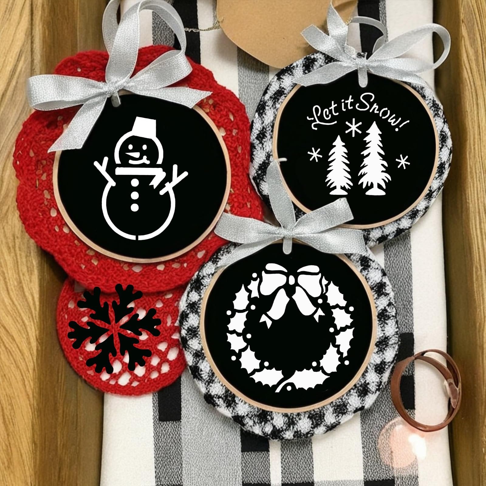 Christmas stencils featuring a snowman, trees, and a wreath, tied with silver ribbons.