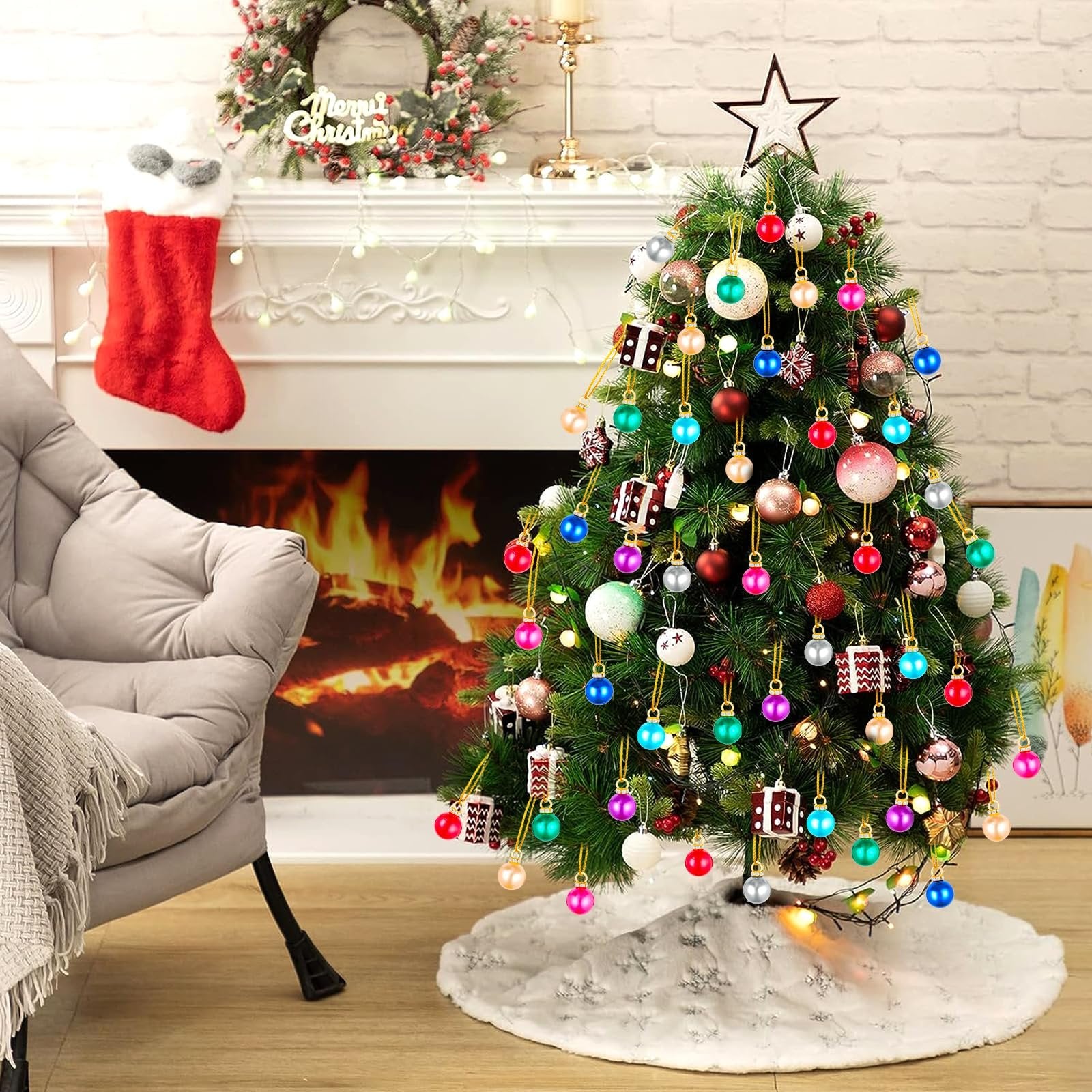 Decorated Christmas tree with colorful mini ornaments, a red stocking, and a fireplace with a roaring fire.