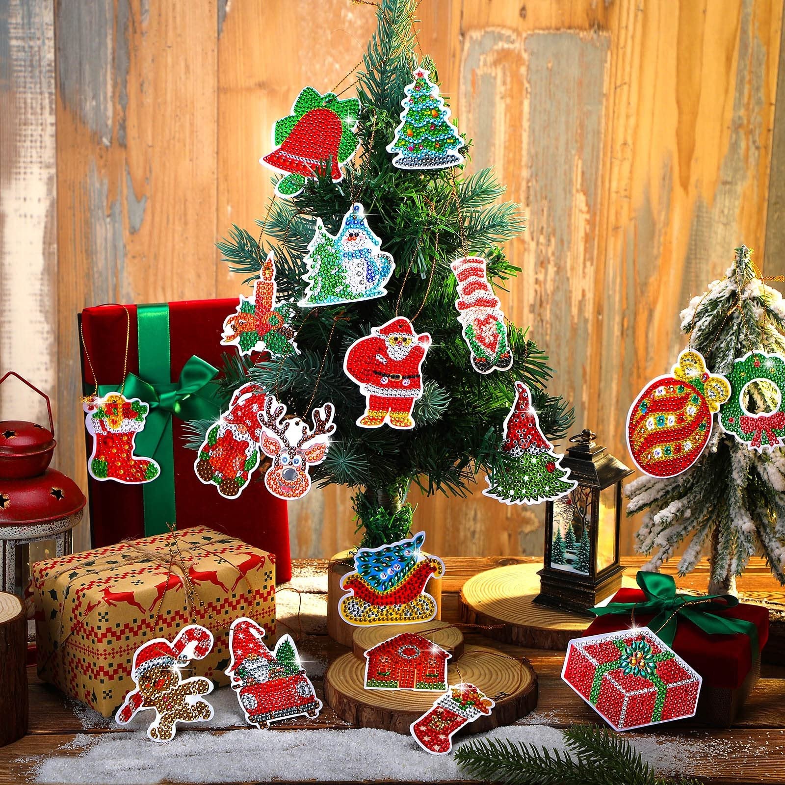 Diamond art Christmas ornaments including Santa, reindeer, snowman, and trees hanging on a small artificial tree.