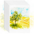Stack of 5x7 inch watercolor paper sheets featuring a landscape painting of a tree in a field under a blue sky.