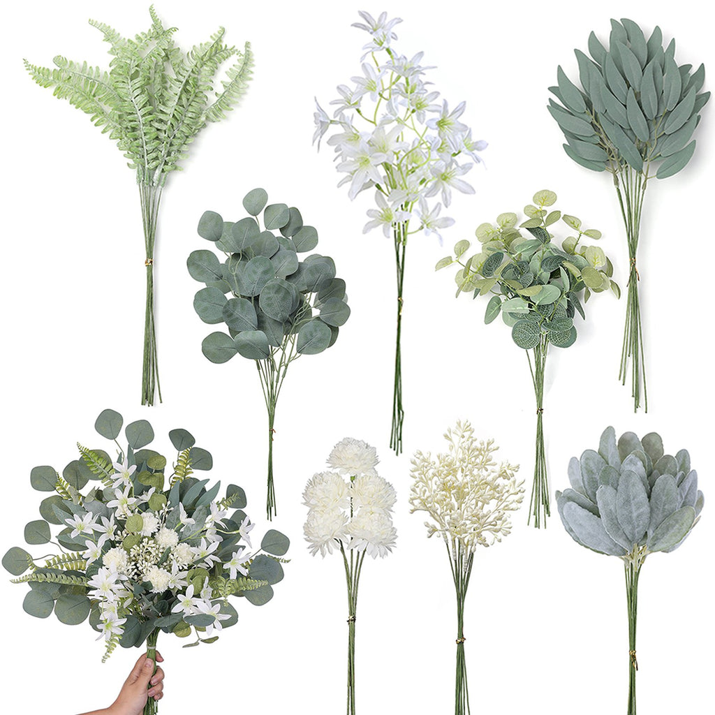 Collection of artificial greenery stems and floral arrangements in various shades of green and white, held by a hand.
