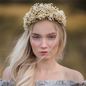 Young woman wearing a crown made of dried baby's breath flowers, outdoors