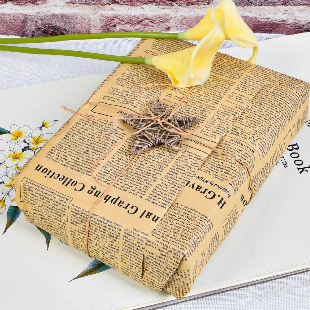 Wrapped gift box with newspaper-style paper, twine, and a star ornament, adorned with yellow calla lilies.