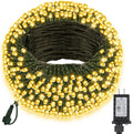 Coiled warm white LED Christmas string lights with a black power adapter on a white background.
