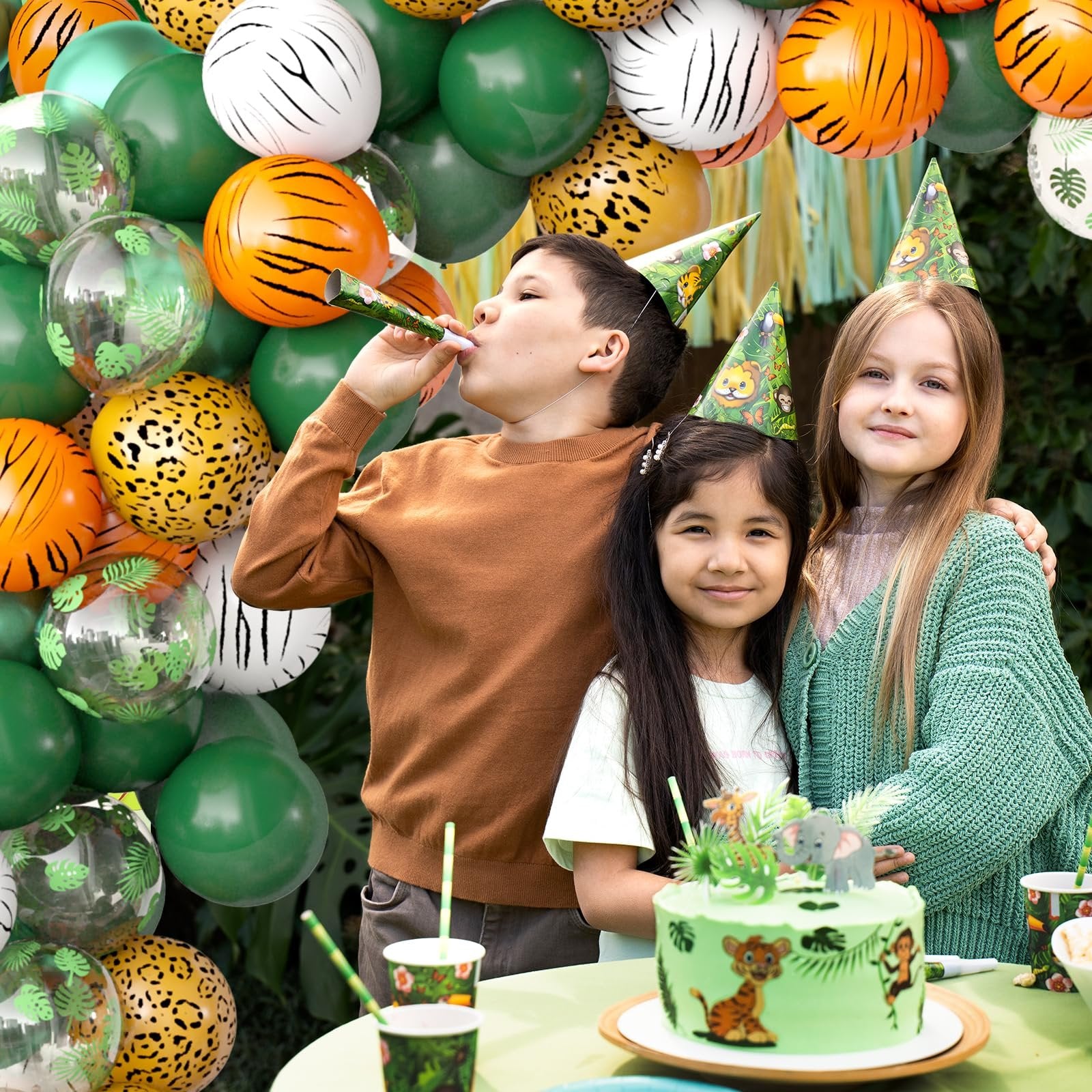 Children celebrating a jungle safari themed birthday party with animal print balloons and a decorated cake.