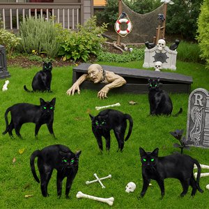 Six black cat silhouettes with green eyes scattered on grass, with a zombie figure emerging from a coffin in the background.