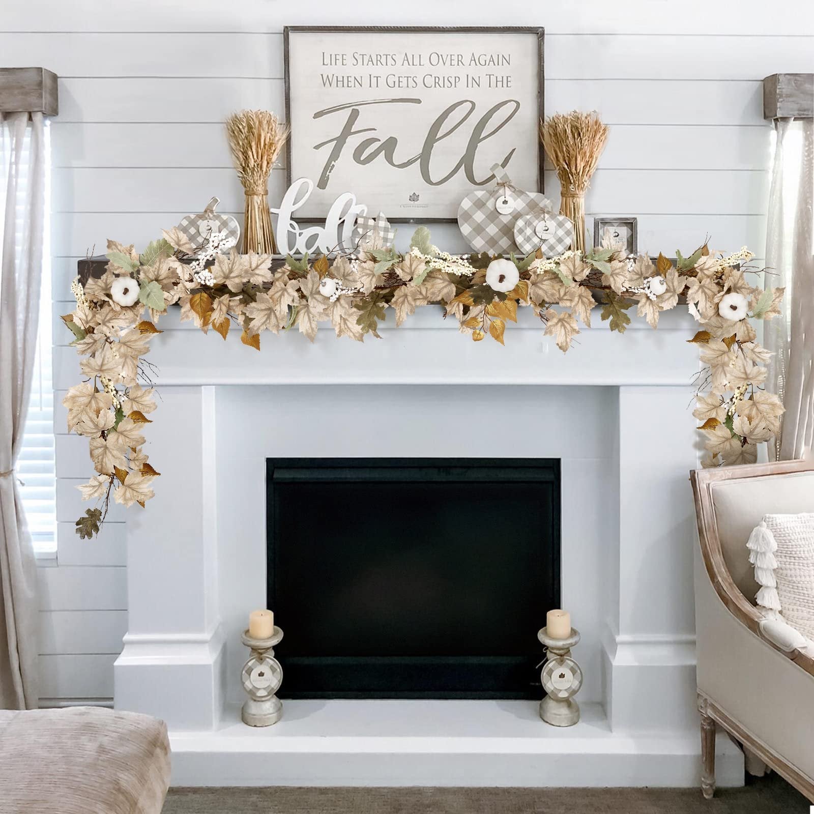 Autumn garland with maple leaves, pumpkins, and berries draped over a fireplace mantle.