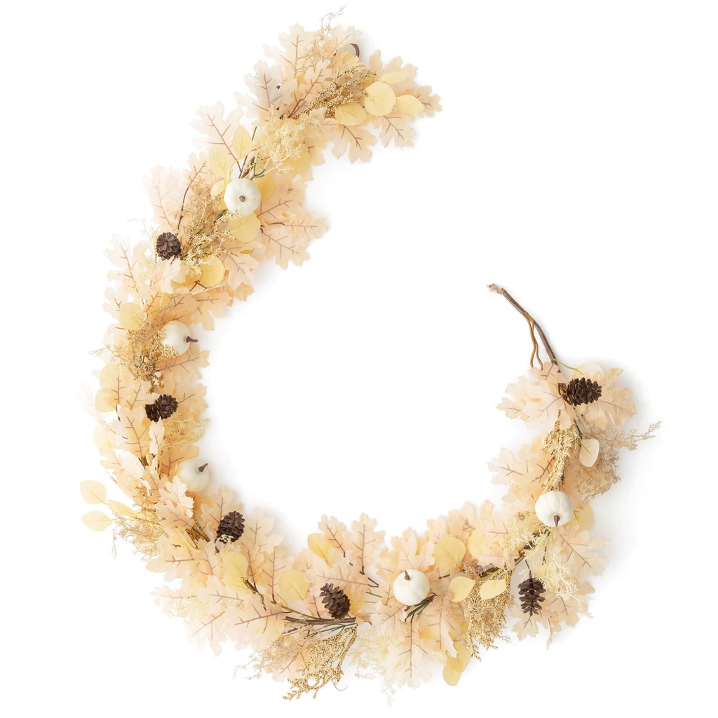 Boho fall garland with artificial oak leaves, white pumpkins, pine cones, and gold accents on a white background.