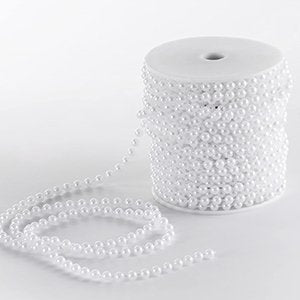 Spool of 6mm white faux pearl garland strand unwinding on a white surface
