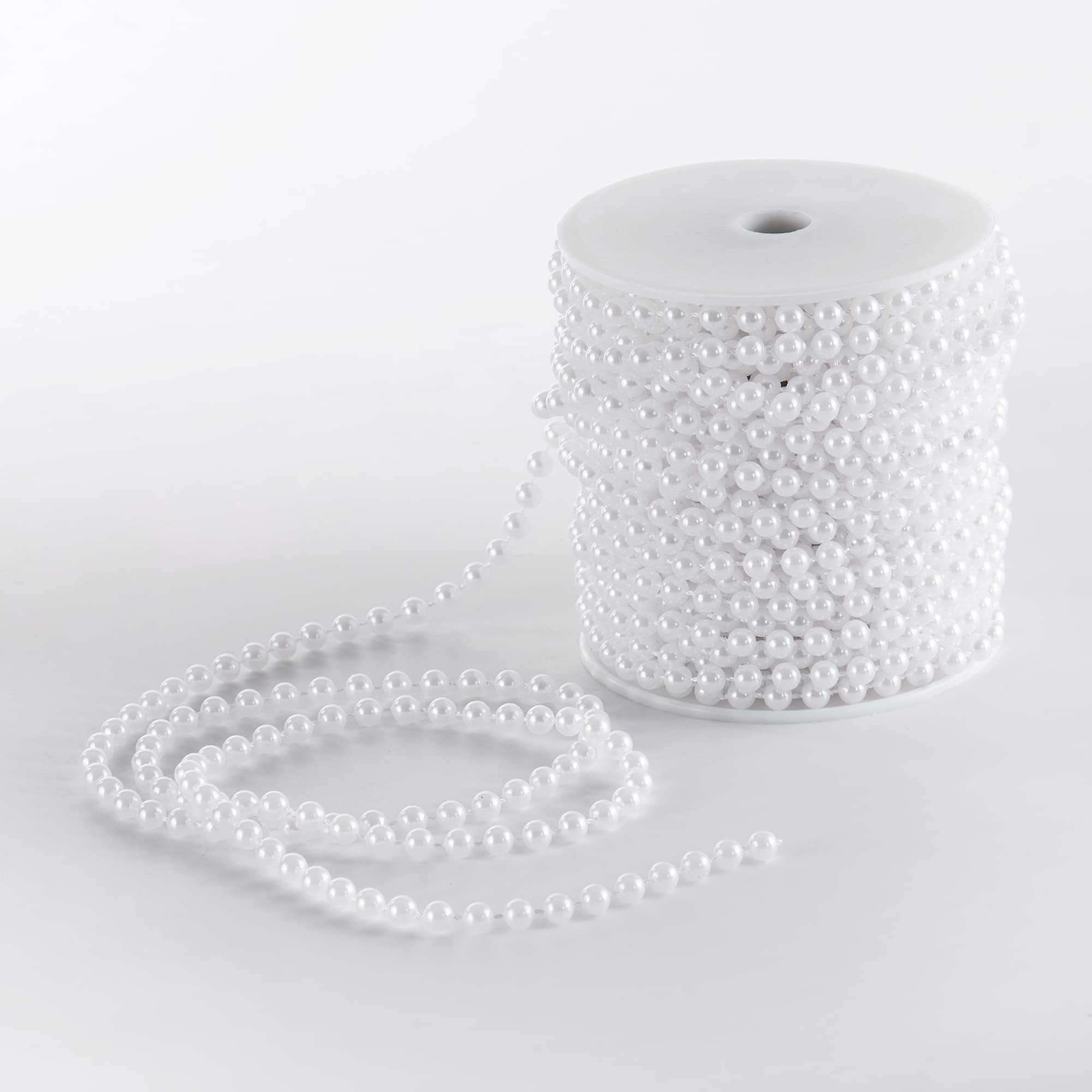 Spool of white faux pearl garland strand on a white background