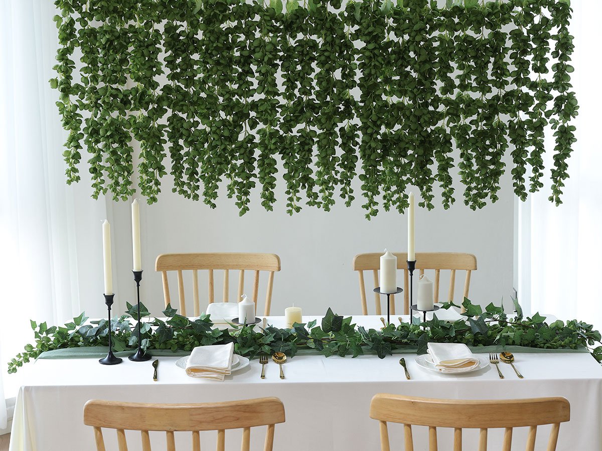 Table setting with hanging artificial green vines and candles for decoration