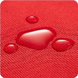 Close-up of red waterproof fabric with water droplets beading on the surface.