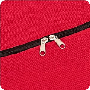 Close-up of two silver zipper pulls on a red storage bag with a black zipper track.