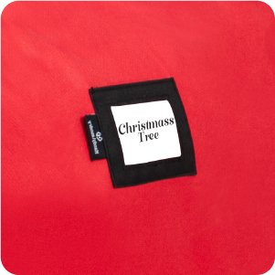 Red Christmas tree storage bag with a black label showing 'Christmass Tree' in white text.