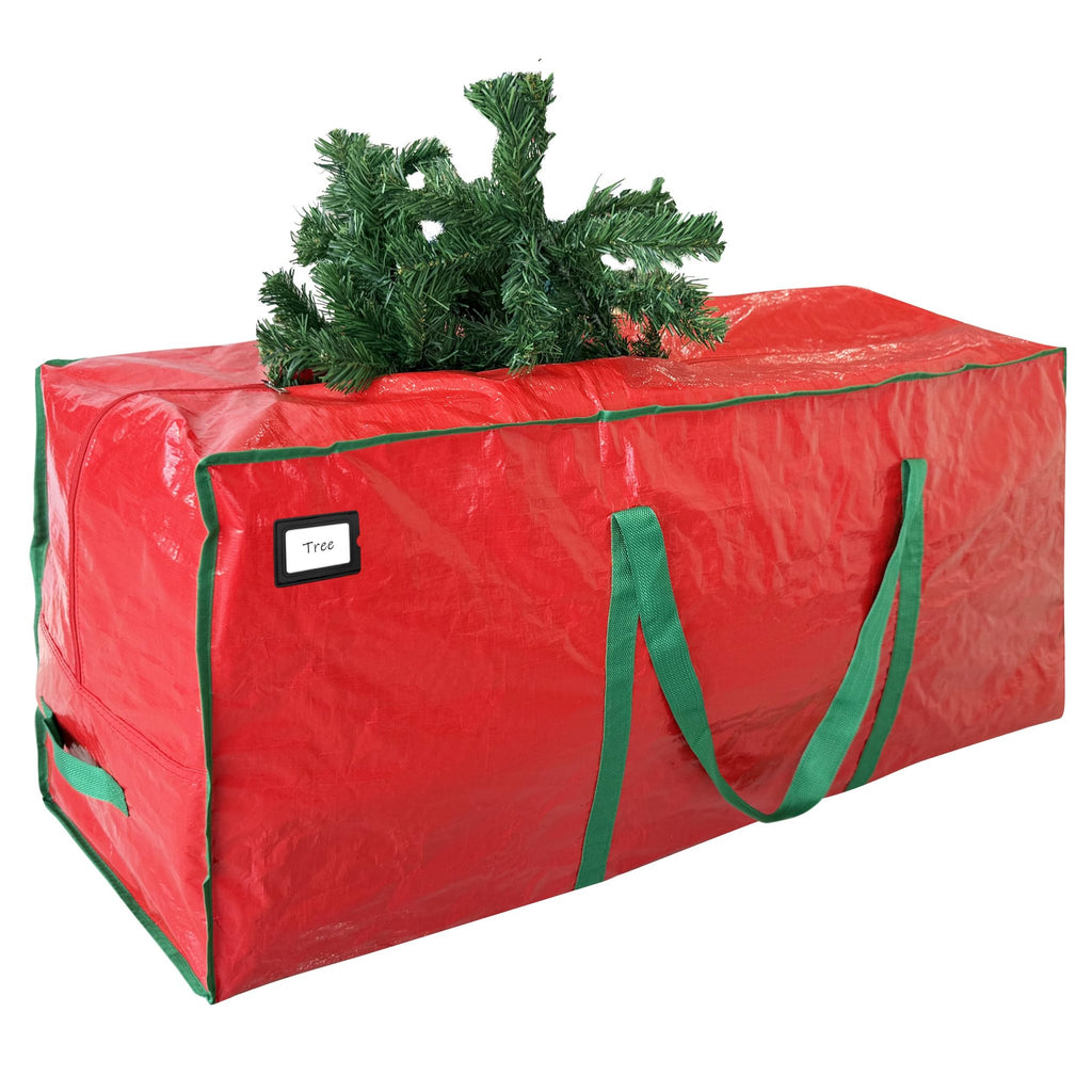 Red Christmas tree storage bag with green handles and trim, a small artificial tree branch sticking out the top.