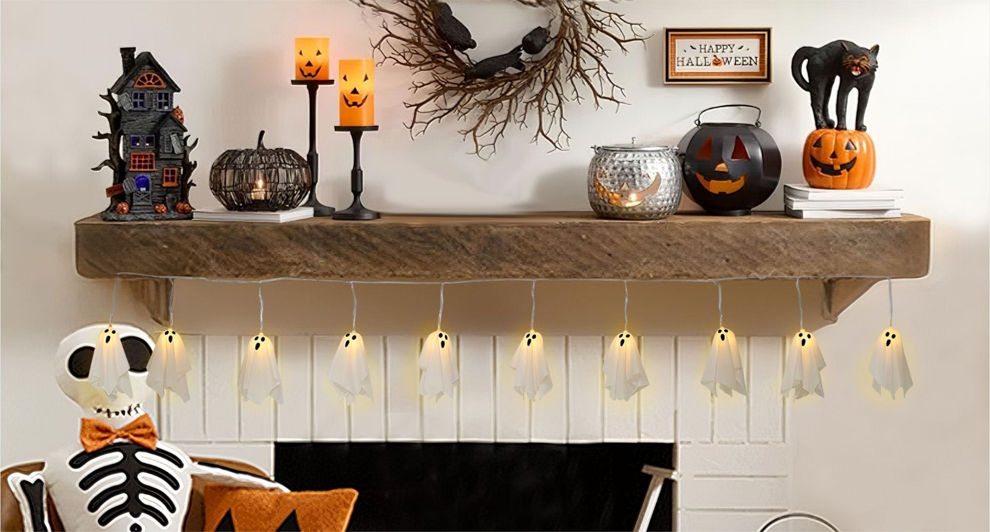 Halloween ghost string lights with 10 LED ghosts draped across a fireplace mantel with other seasonal decorations.
