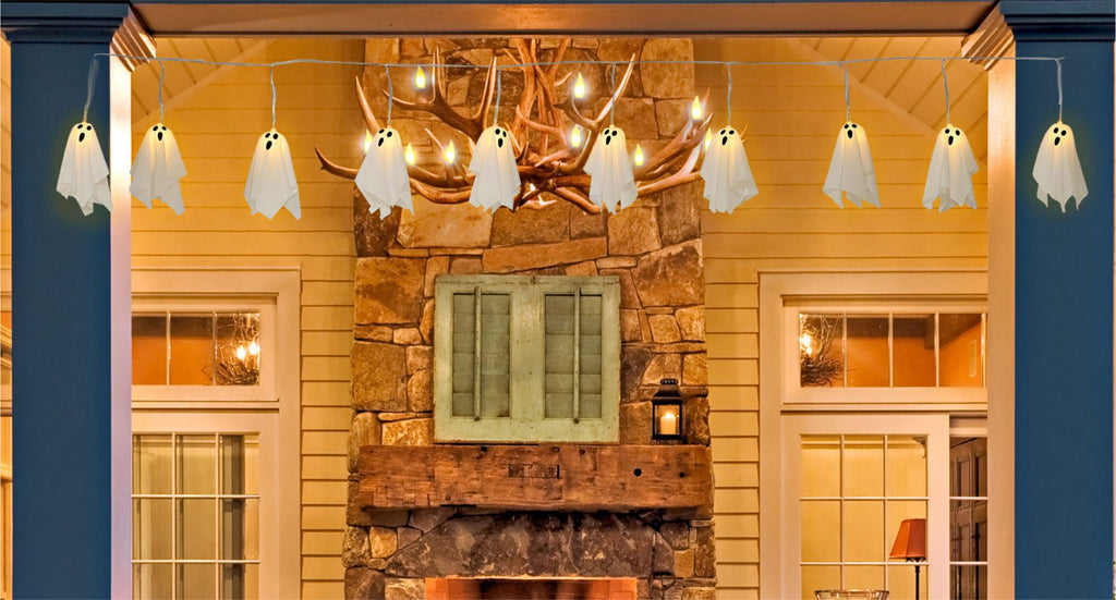 Ghost string lights with 10 LED ghosts hanging on a house exterior at dusk