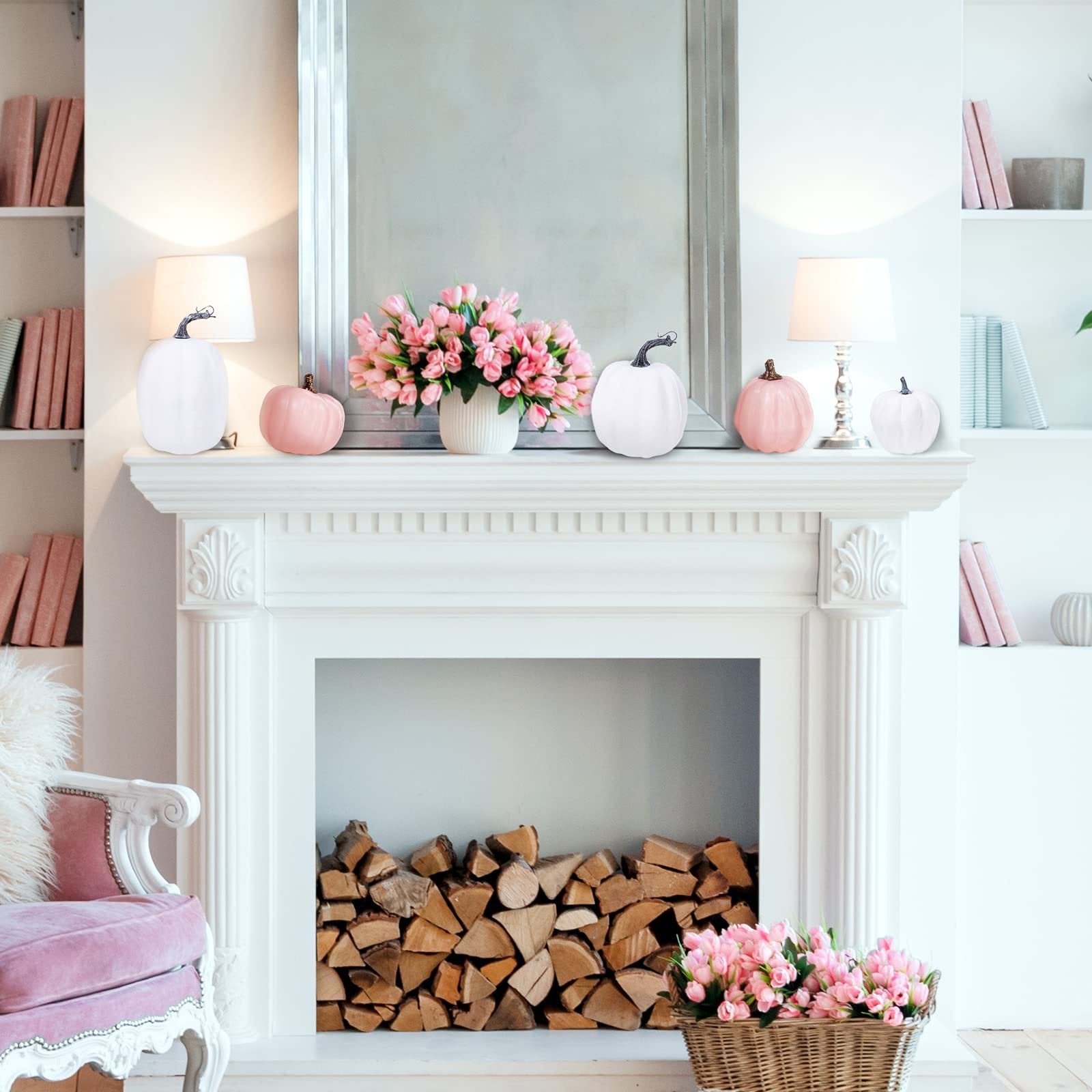 Assorted pink and white foam pumpkins arranged on a white fireplace mantel with a mirror and floral arrangements.