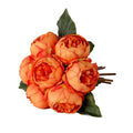 Bouquet of seven orange peony flowers with green leaves and brown stems on a white background.