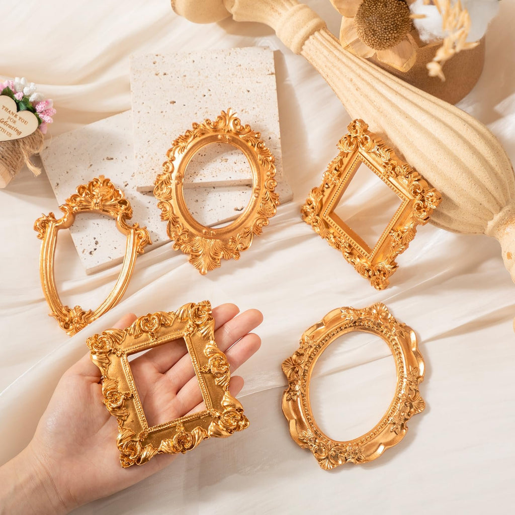 Set of 5 antique gold resin picture frames with ornate baroque detailing, one held in a hand.