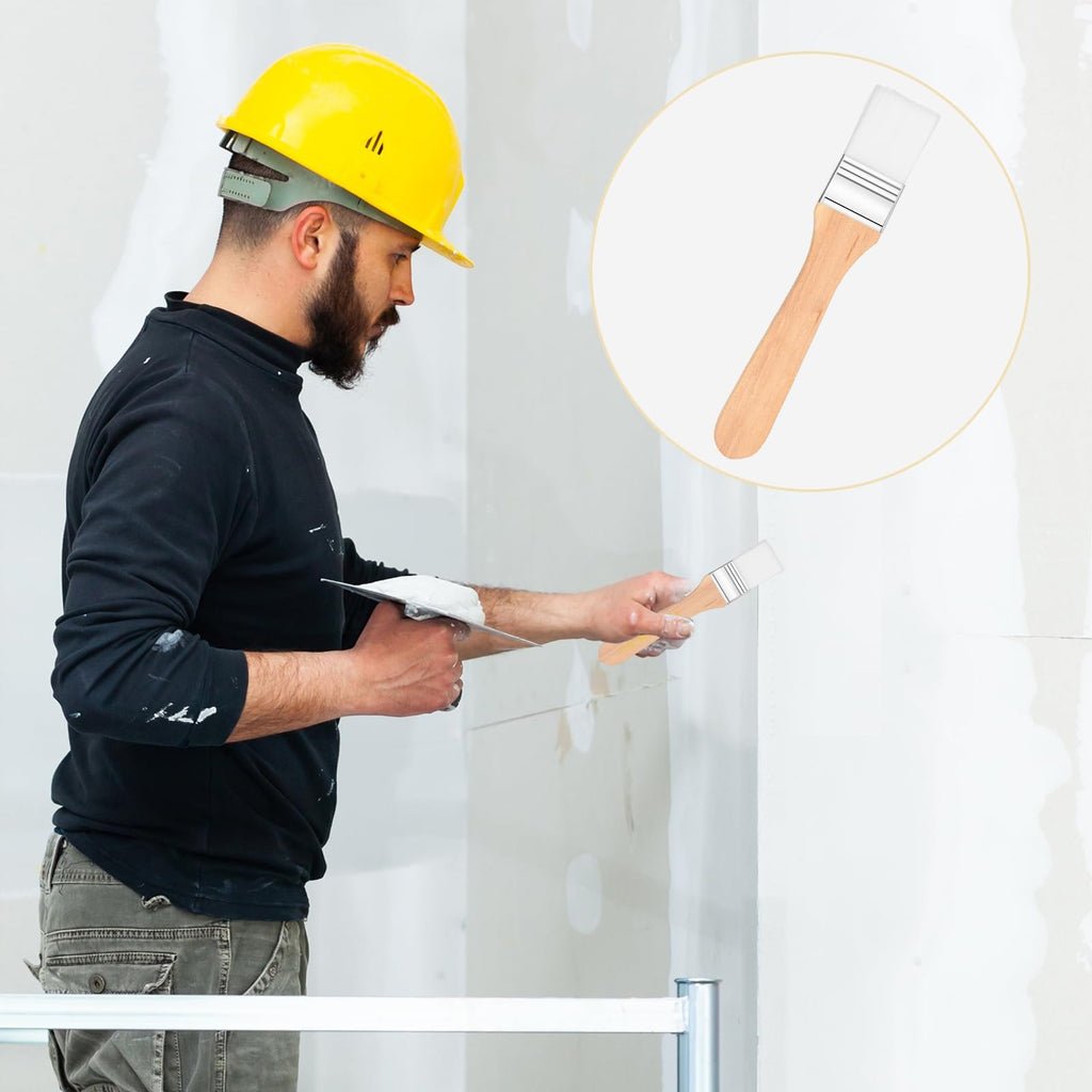 Construction worker in yellow hard hat applying compound to wall with trowel, inset shows a paintbrush