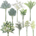 Collection of artificial greenery stems including eucalyptus, fern, lamb's ear, and rosemary on white background.