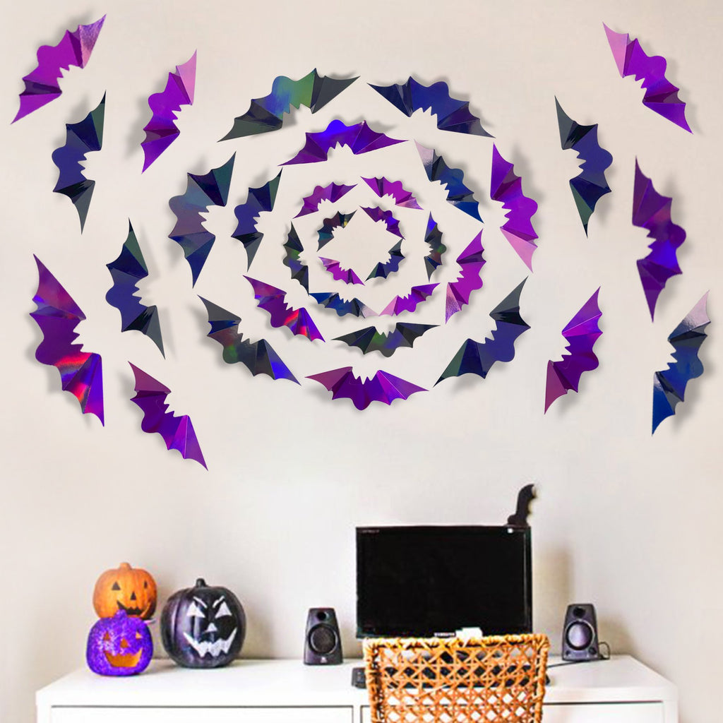 Iridescent 3D bat wall decals arranged in a circular pattern on a wall above a dresser with Halloween decorations.