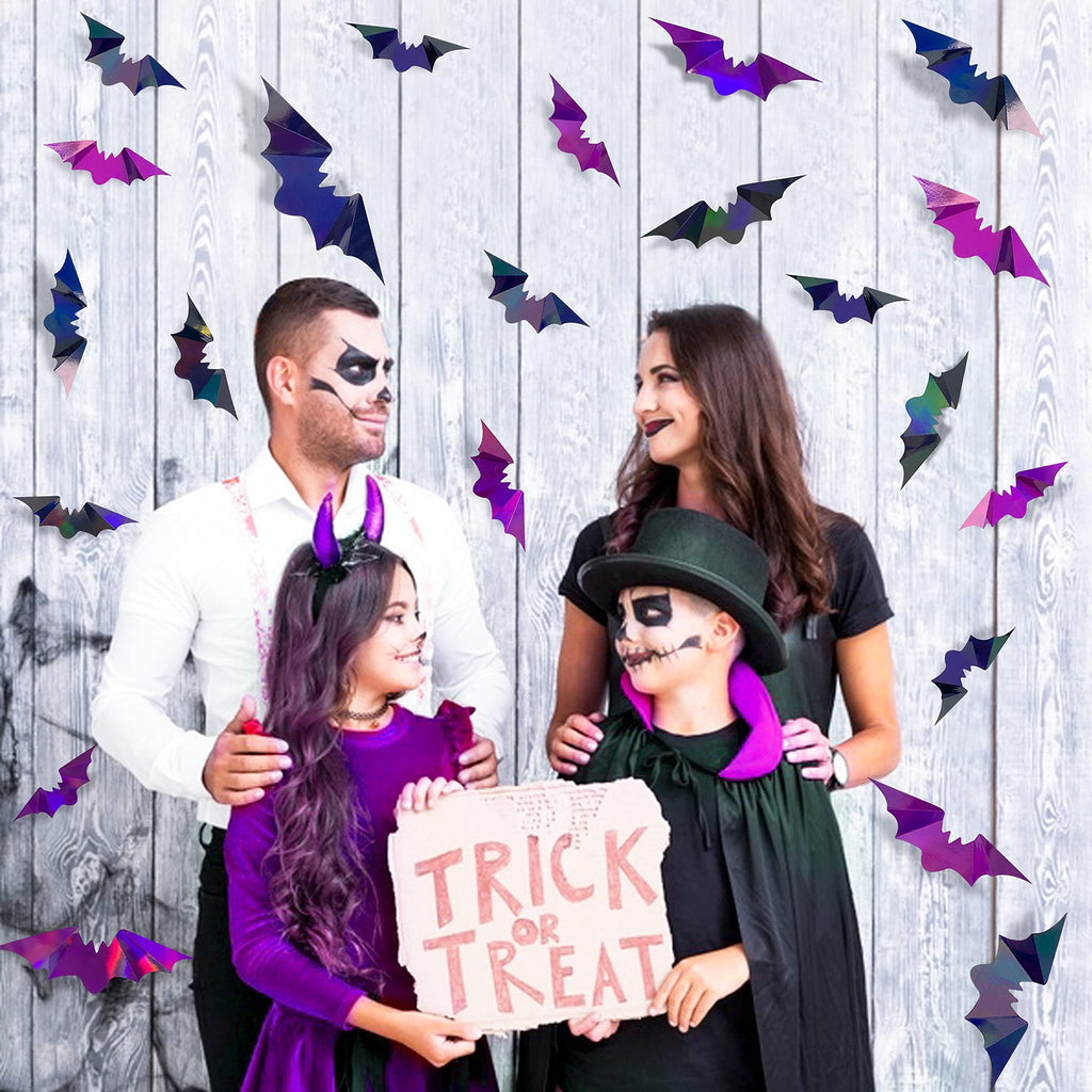 Family in Halloween costumes posing with iridescent bat decorations and a trick or treat sign