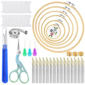 Cross stitch kit contents including embroidery hoops, needles, scissors, thread bobbins, and measuring tape on a white background.