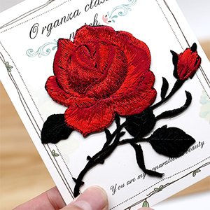 Red rose and bud applique patch with black leaves on a card with text