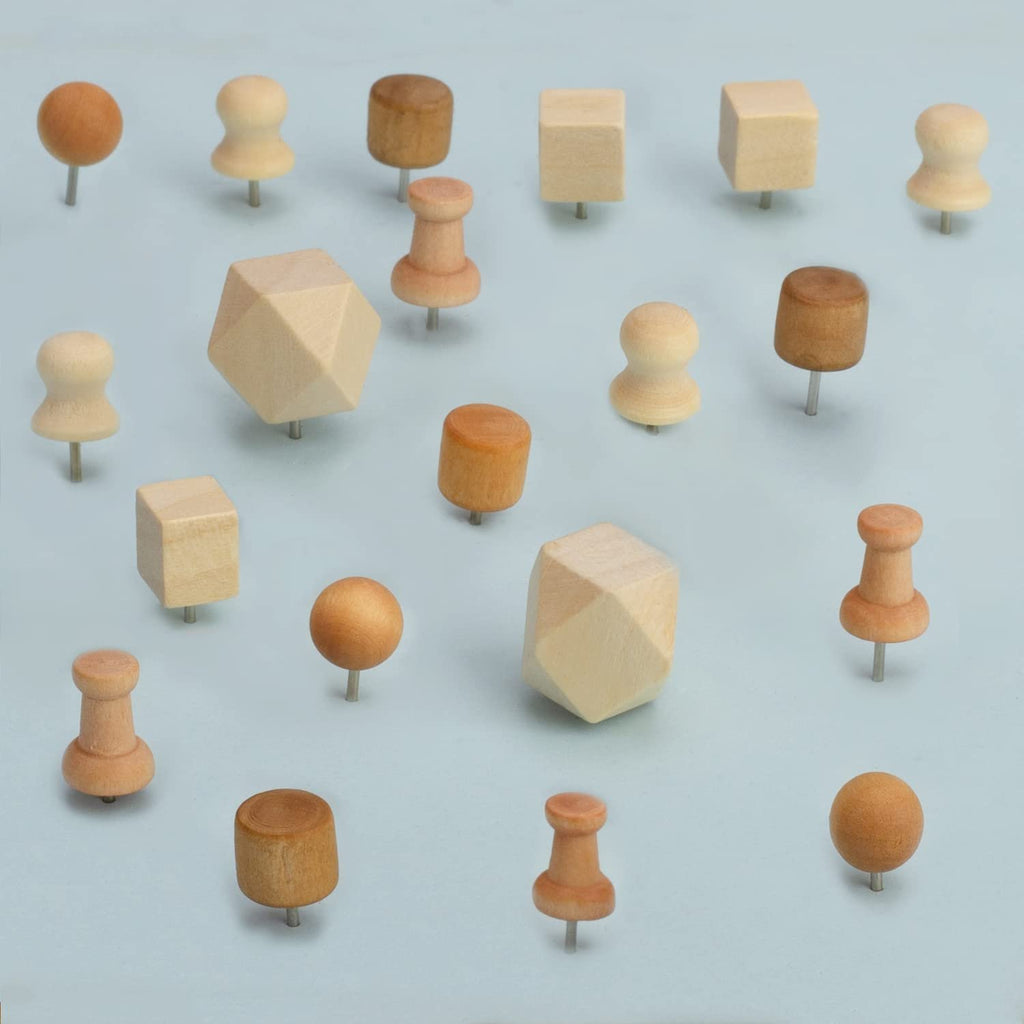 Assorted wooden push pins in various shapes including spheres, cubes, and classic push pin designs on a light blue background.