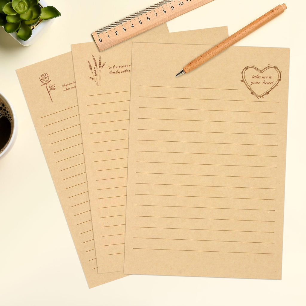Three lined kraft writing papers with vintage floral and heart designs, a pencil, and a ruler on a desk.